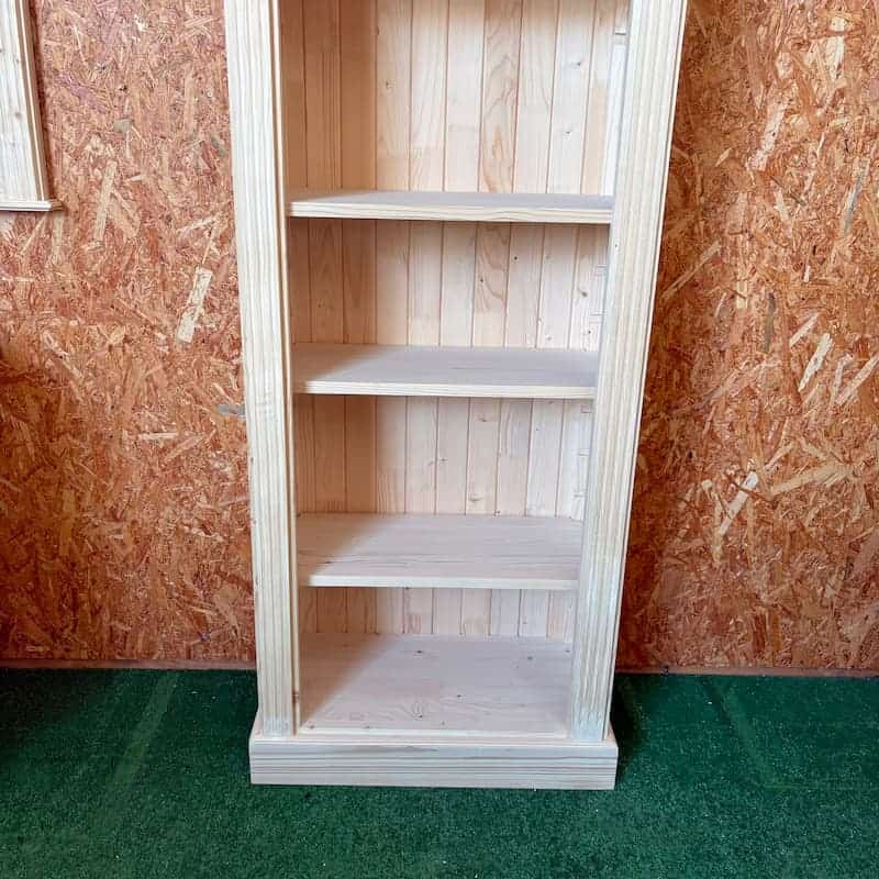 Bibliothèque artisanale en bois clair posée contre un mur OSB lokimob LM161